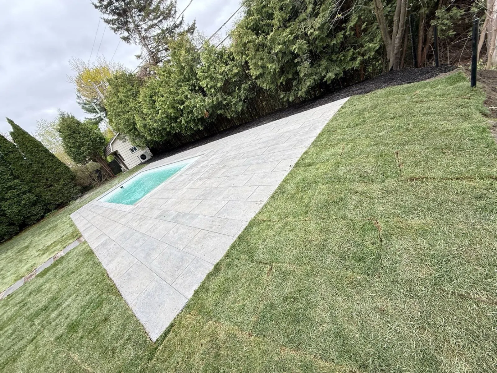Réalisation de Groupe Paysager NG : pavé uni et pelouse autour de la piscine, Rive-Sud de Montréal